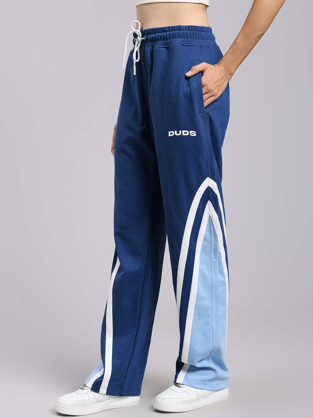 Woman wearing blue relaxed fit joggers with side stripes, showcasing comfortable and breathable streetwear fashion.