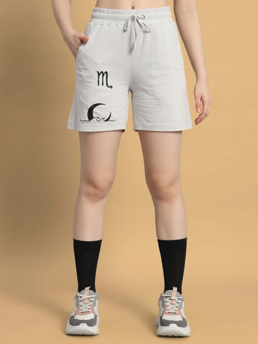 Women's grey Scorpius co-ord shorts with printed design in premium cotton fabric, styled with black socks and sneakers.