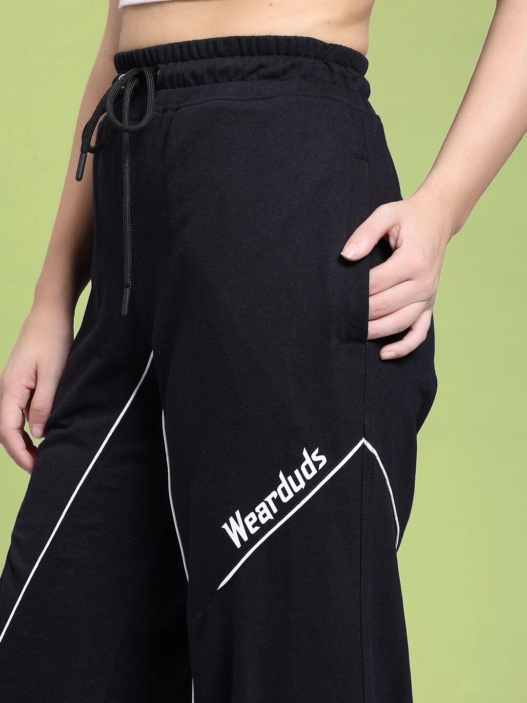 Close-up of WOMEN SIGNATURE PIPING JOGGERS BLACK in premium stretch-cotton, showcasing contrast piping on a model.