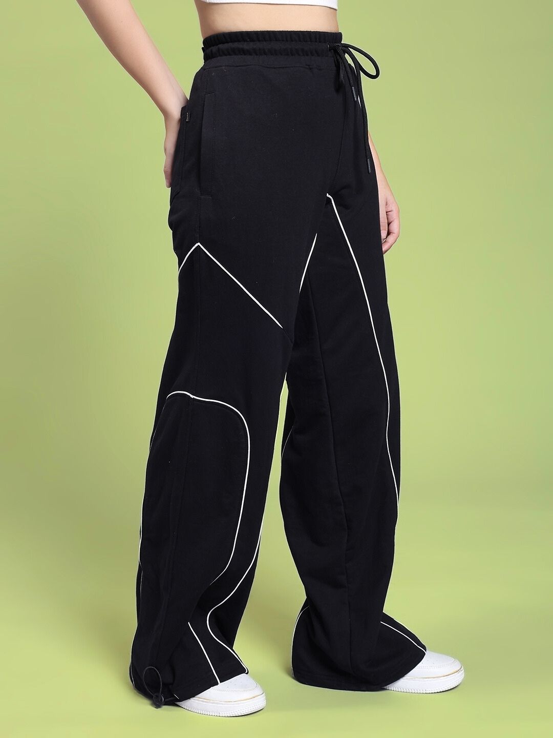Model wearing WOMEN SIGNATURE PIPING JOGGERS BLACK with contrast piping detail, showcasing sleek and modern style.