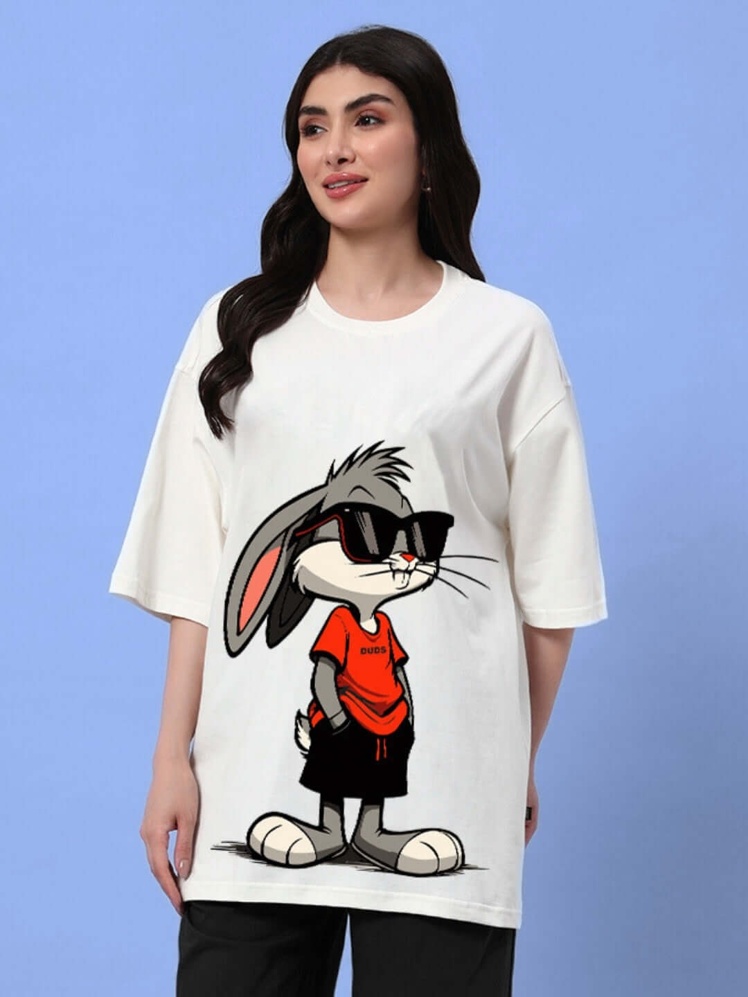 Woman wearing oversized white t-shirt with cartoon bunny graphic, perfect for trendy summer look with breathable cotton fabric.