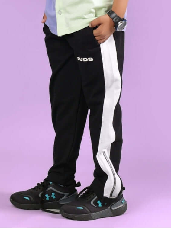 Child wearing black Wonder Jogger for boys and girls, featuring a white stripe design, crafted by DUDS tailors.