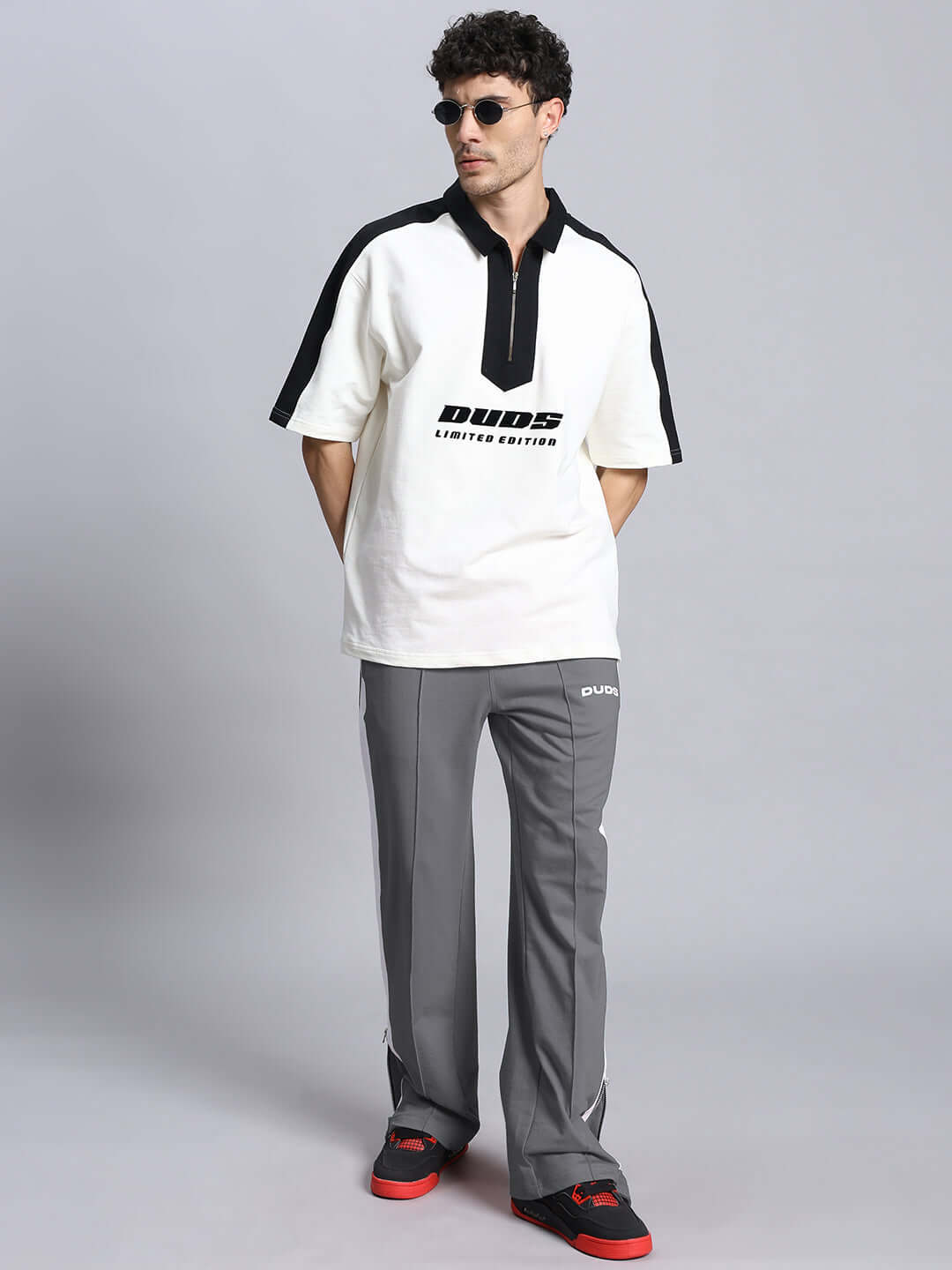 Model wearing grey white WONDER SLIT ZIPPER JOGGERS with black and white shirt, from DUDS collection, showcasing a stylish casual outfit.