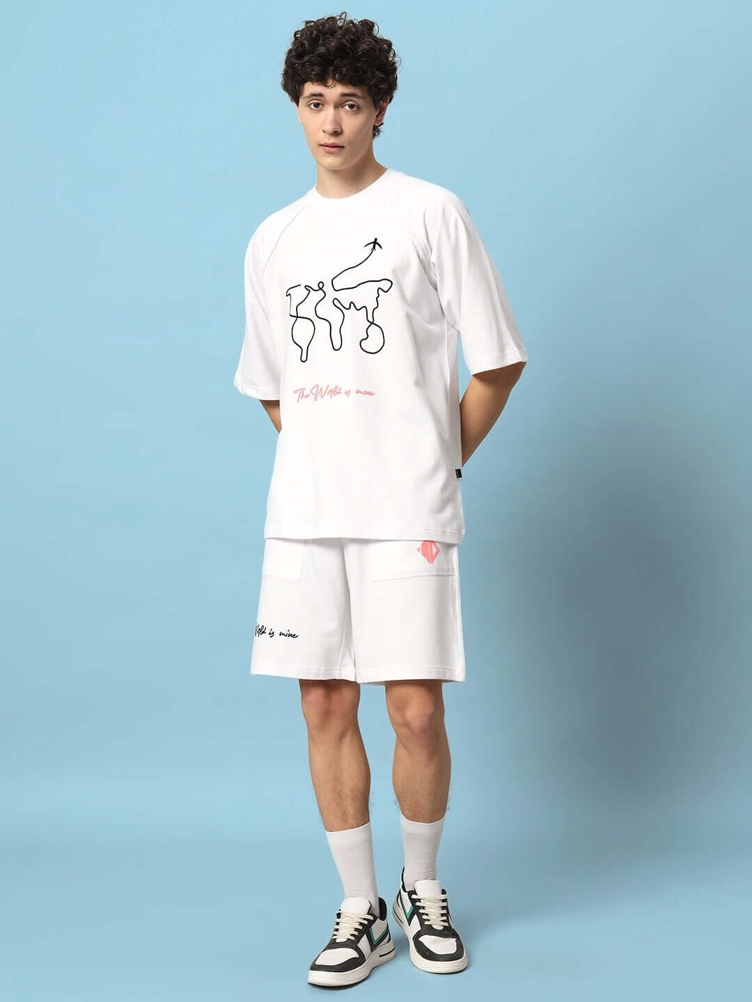 Model wearing 'The World Is Mine' printed white co-ord set, premium cotton fabric, showcasing stylish design on blue background.
