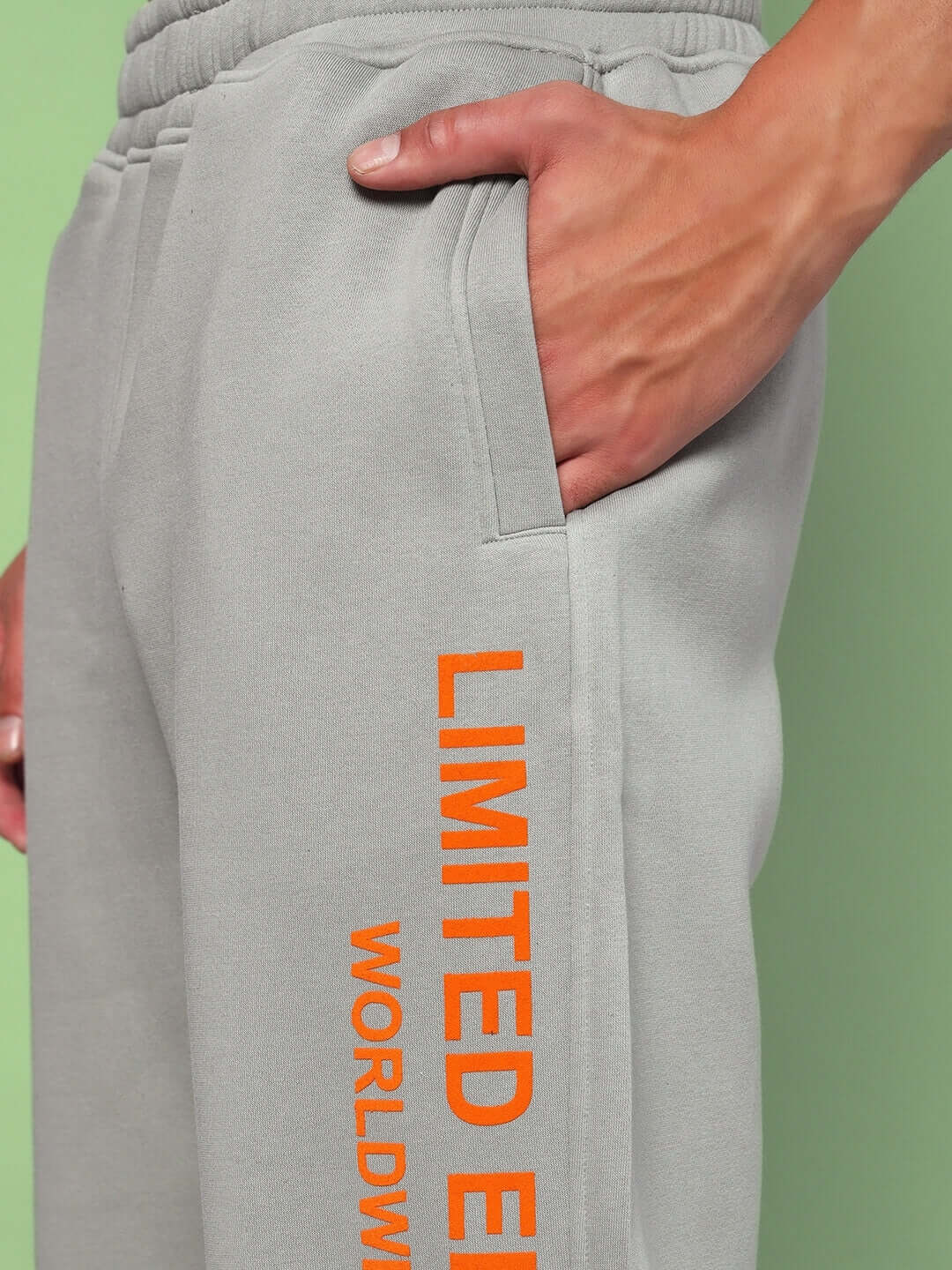 Close-up of grey sweatpants from WORLDWIDE FLEECE COLORBLOCK CO-ORD GREY with orange text detail.