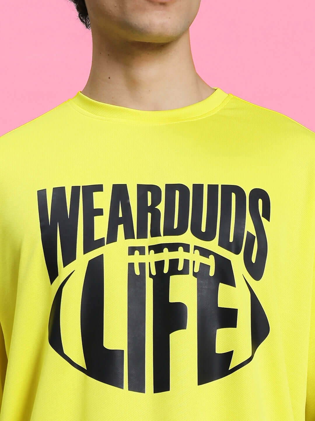 Bright yellow t-shirt with "WEARDUDS LIFE" graphic design against pink background.