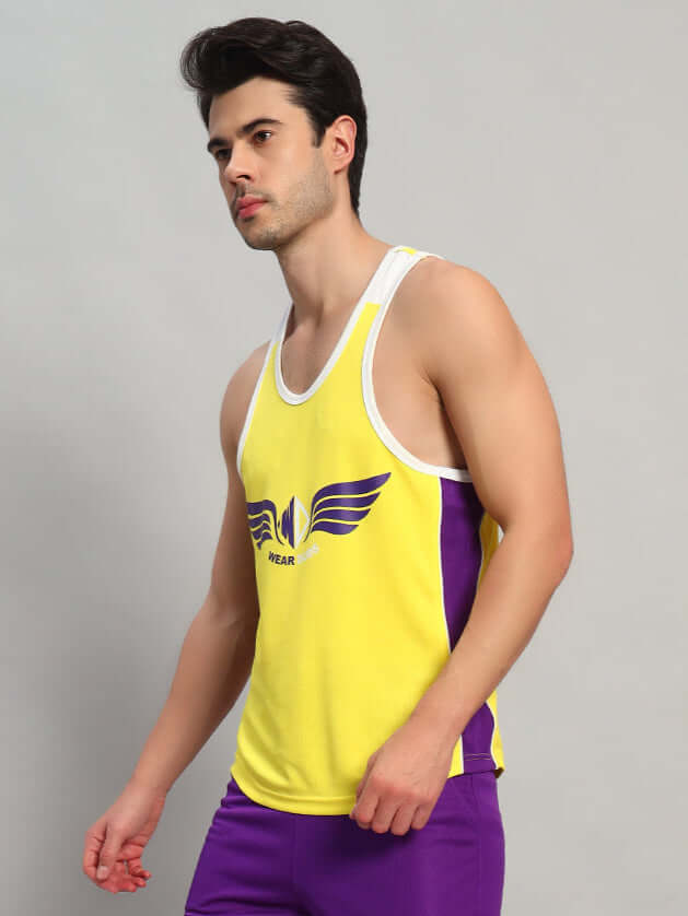Man wearing yellow Zenith gym t-shirt with purple accents standing against a plain background