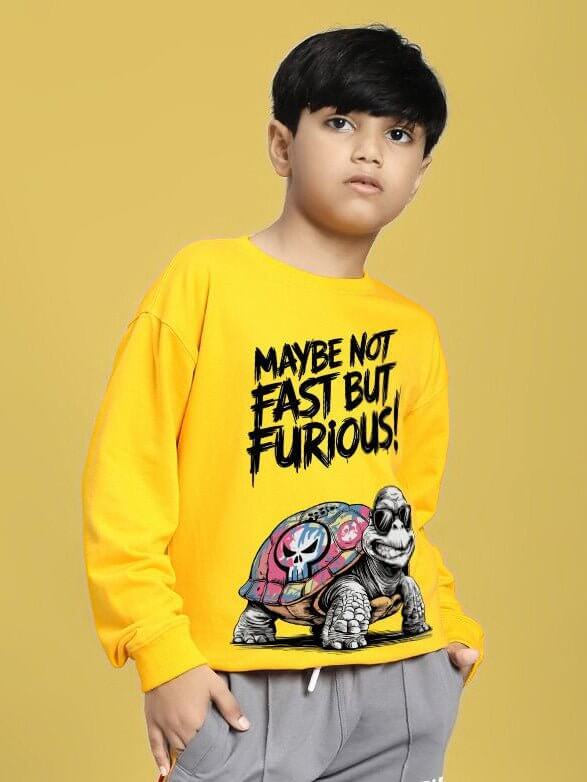 Child wearing NOT FAST BUT FURIOUS PRINT SWEATSHIRT BOYS AND GIRLS YELLOW with turtle graphic on yellow background.