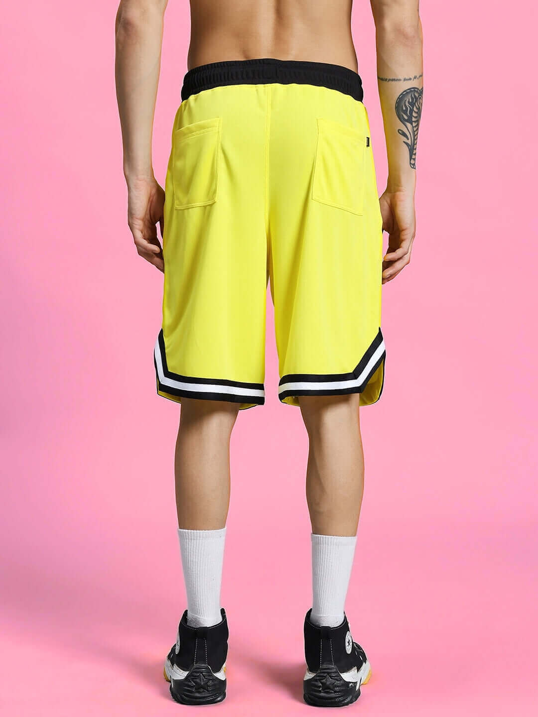 Back view of VIGOR REGULAR FIT SHORTS YELLOW with elastic waistband and black trim, perfect for a stylish and comfortable fit.