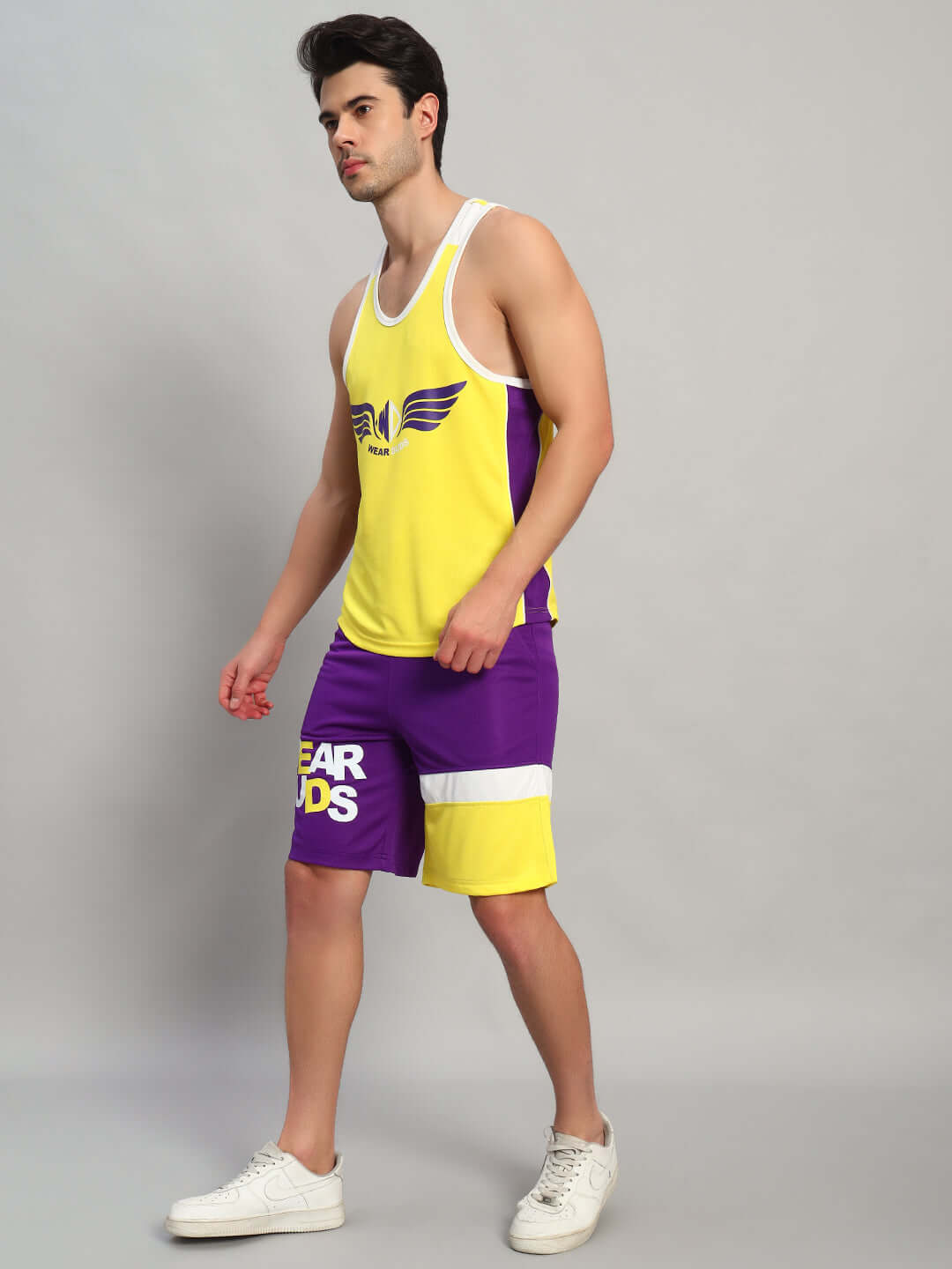 Alt Tag: Man wearing ZENITH GYM CO-ORD SET YELLOW-PURPLE showcasing athletic style and vibrant color for peak performance.