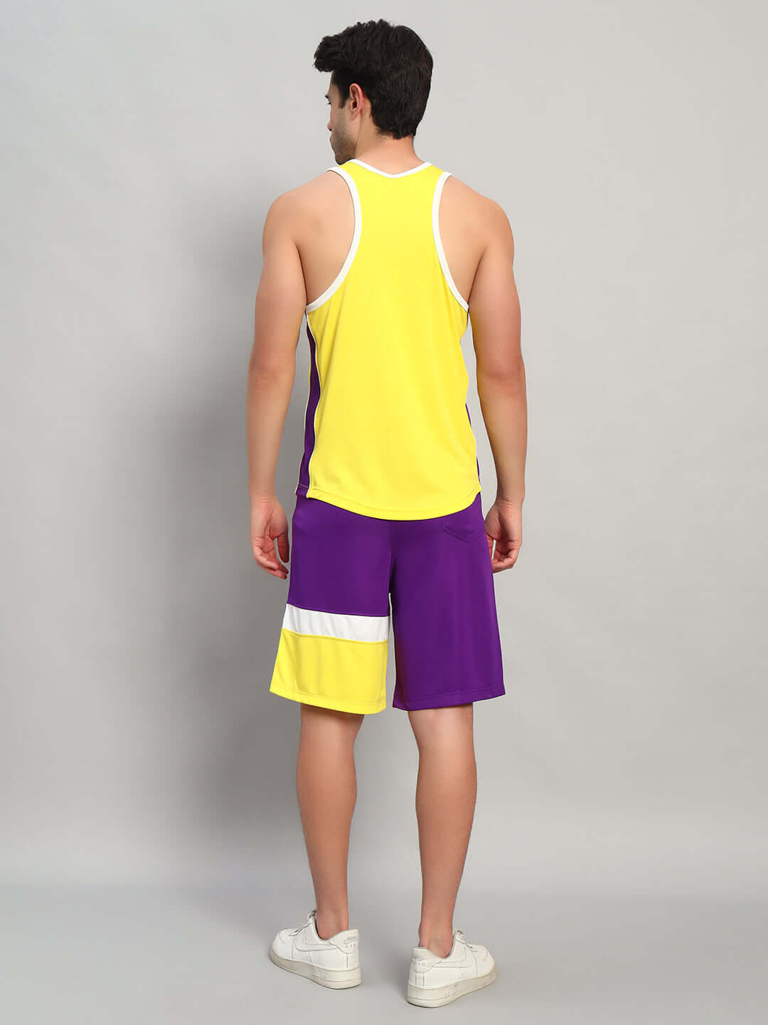 Back view of model wearing ZENITH GYM CO-ORD SET YELLOW-PURPLE, showcasing athletic and stylish gym attire with vibrant colors.