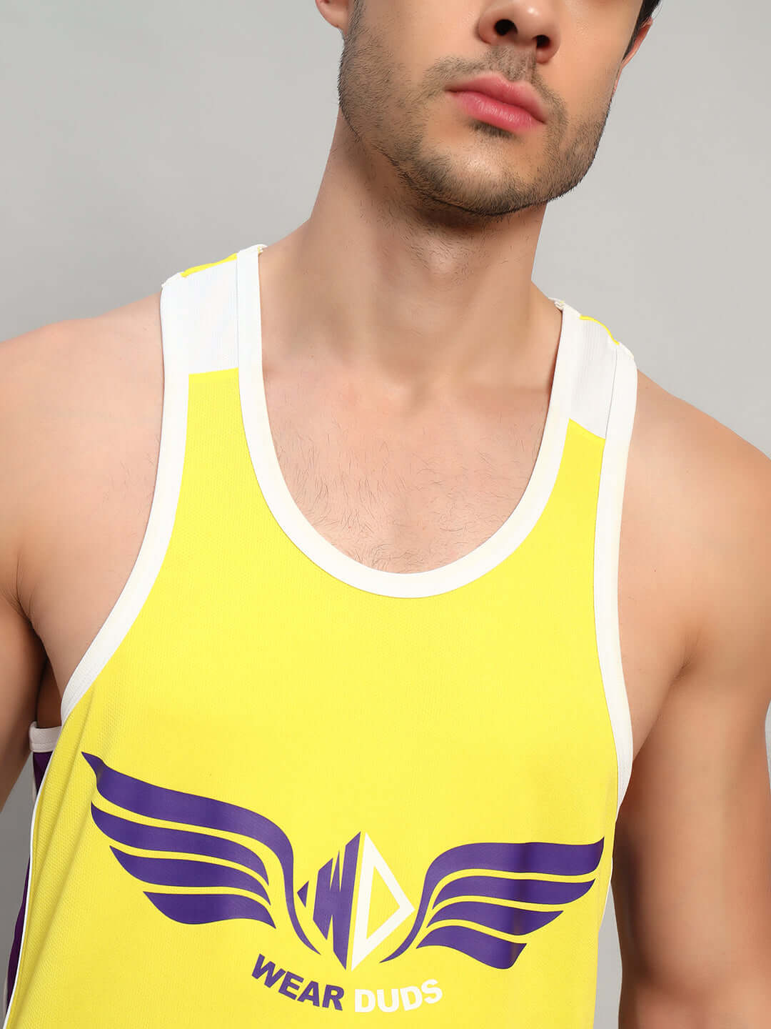 Close-up of man wearing yellow Zenith Gym T-shirt by DUDS with purple logo and white trim, customizable for perfect fit.