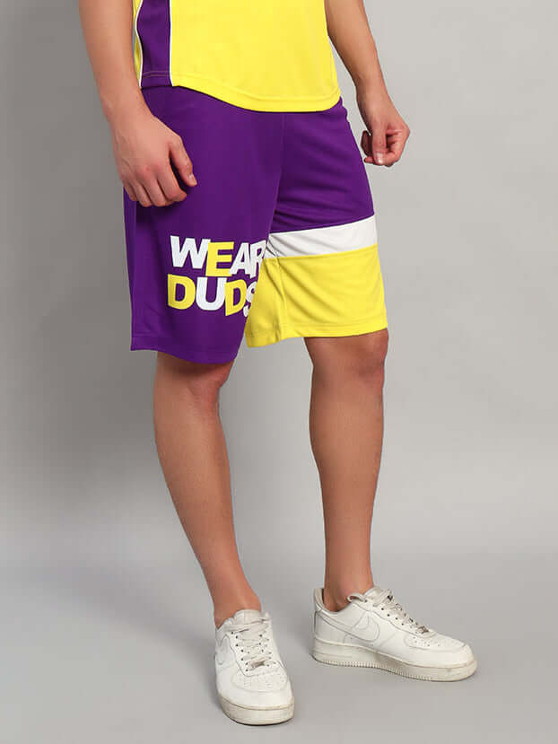 Person wearing ZENITH REGULAR FIT SHORTS PURPLE YELLOW with sporty design, vibrant purple and yellow color blocking, ideal for athletic wear.