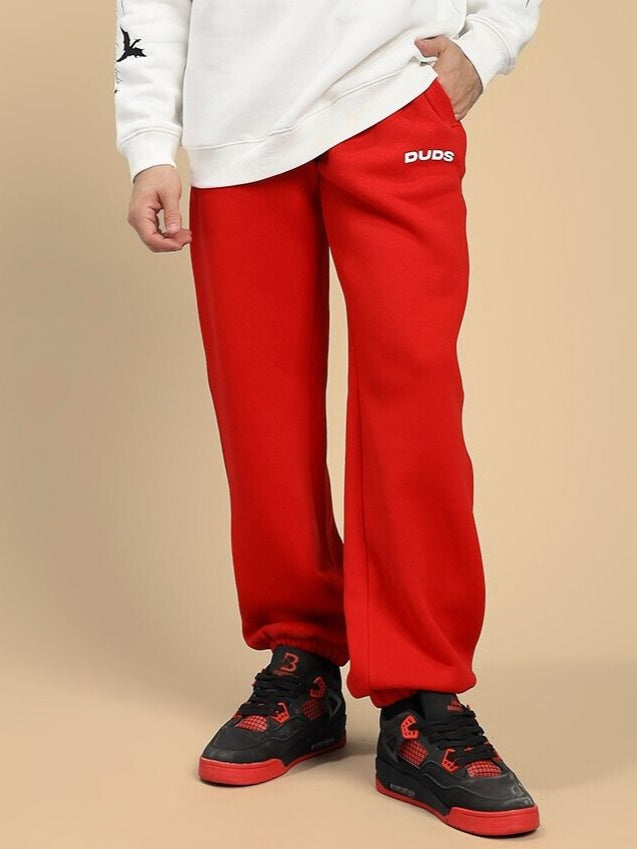 Person wearing ZENO RELAXED FIT FLEECE JOGGER RED with sneakers.