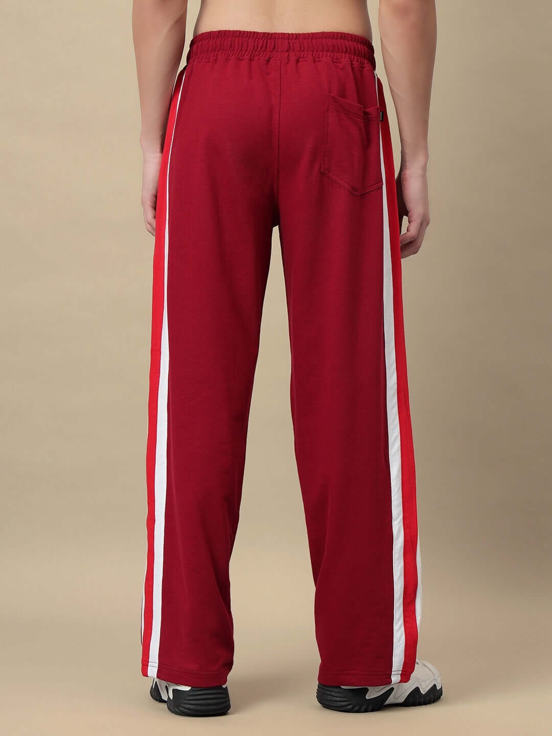 Model wearing maroon Zest Jogger with white stripes, seen from the back, showcasing comfort and style.