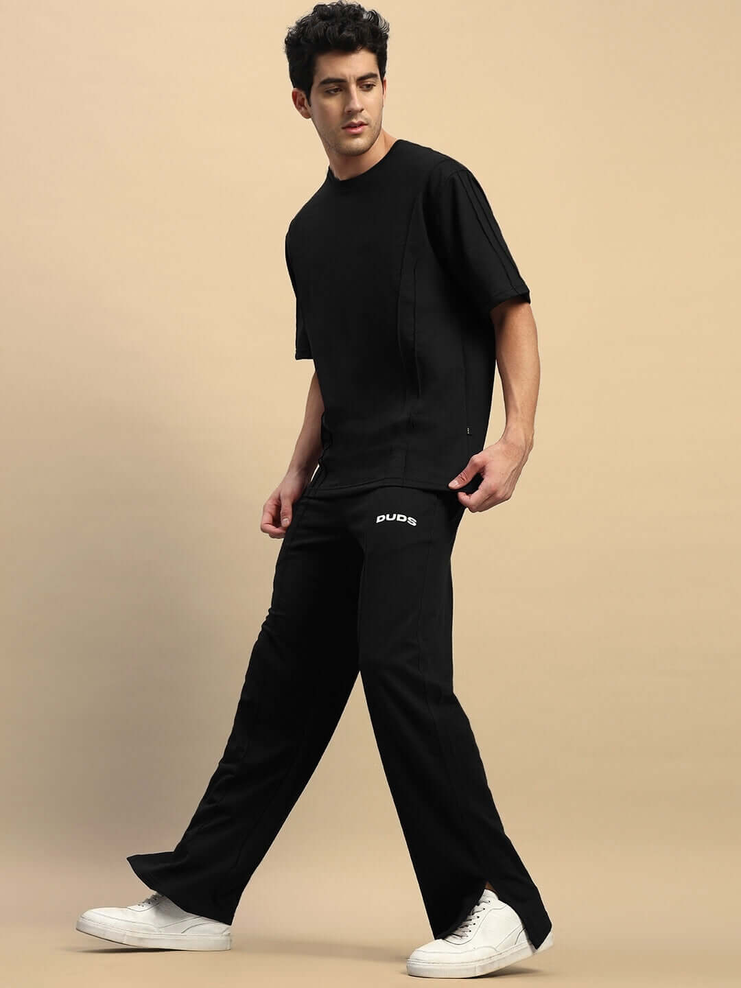 Model wearing ZION relaxed fit black co-ord set, unisex joggers with elasticated waistband and premium cotton t-shirt with a modern design.