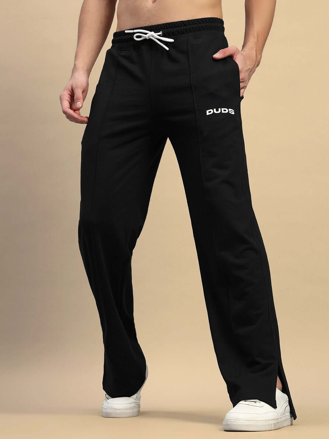 Model wearing black relaxed fit joggers with elasticated waistband and drawstring, featuring 'DUDS' logo.
