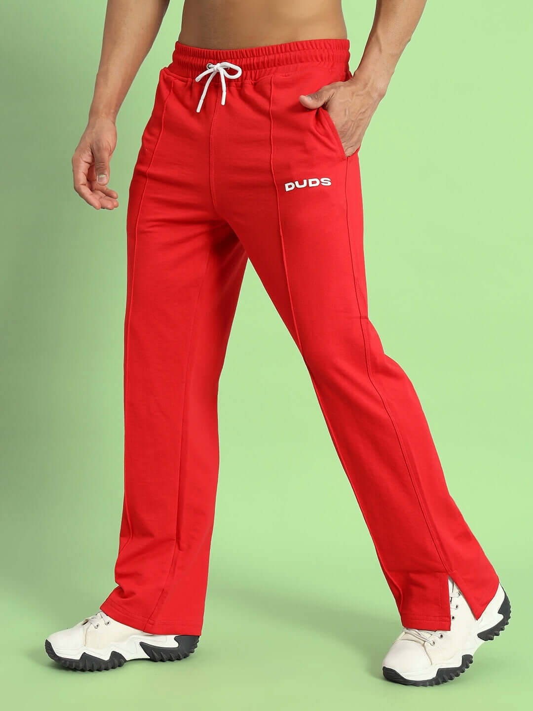 Model wearing red Zion side slit joggers by DUDS highlighting comfort and custom fit option on green background