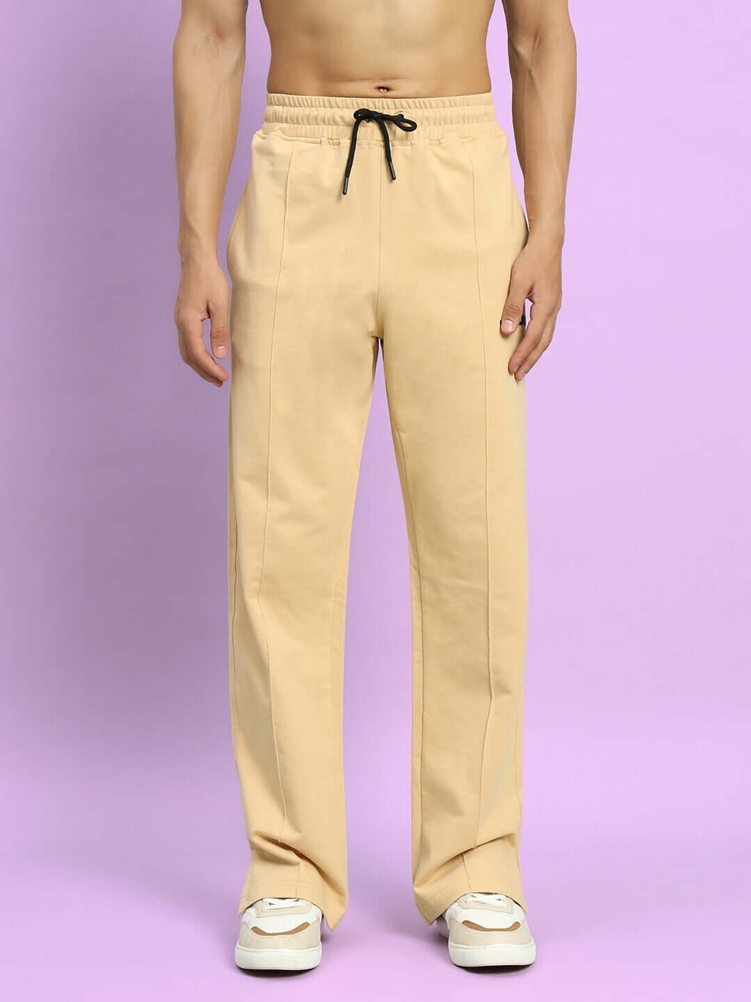 Beige Zion Side Slit Joggers with drawstring, tailored for comfort, modeled against a purple backdrop.