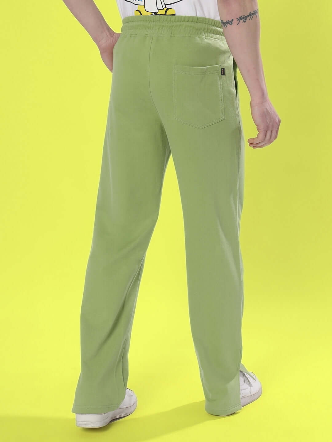 Model wearing Zion Side Slit Joggers in Pista Green, featuring a relaxed fit and back pocket, made to order by skilled tailors at DUDS.