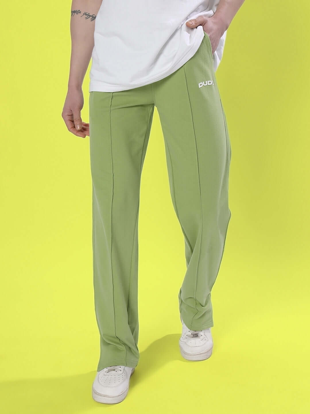 Model wearing pista green Zion side slit joggers by DUDS, highlighting comfortable fit and customizable options.