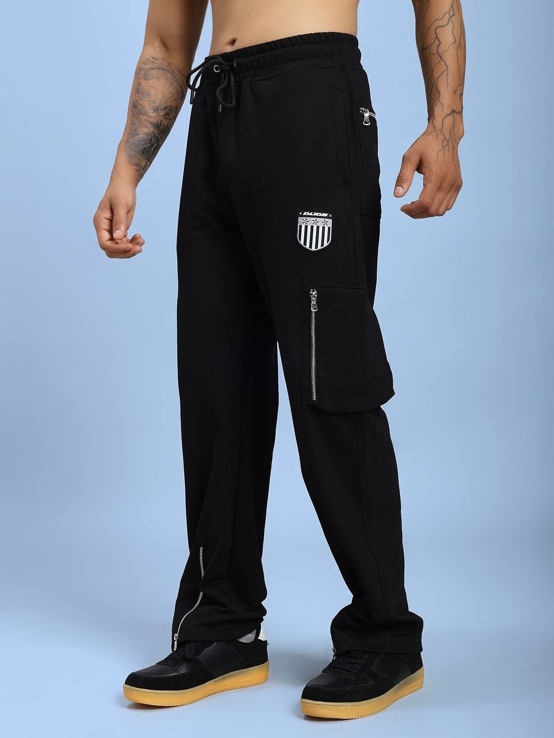 Man wearing ZIP TECH PREMIUM CARGO IN BLACK, showcasing sleek design and cargo pants functionality.