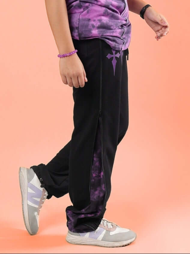 Unisex black and purple zipper panel jogger for kids by DUDS, featuring adjustable fit, shown on model with sneakers and matching top.