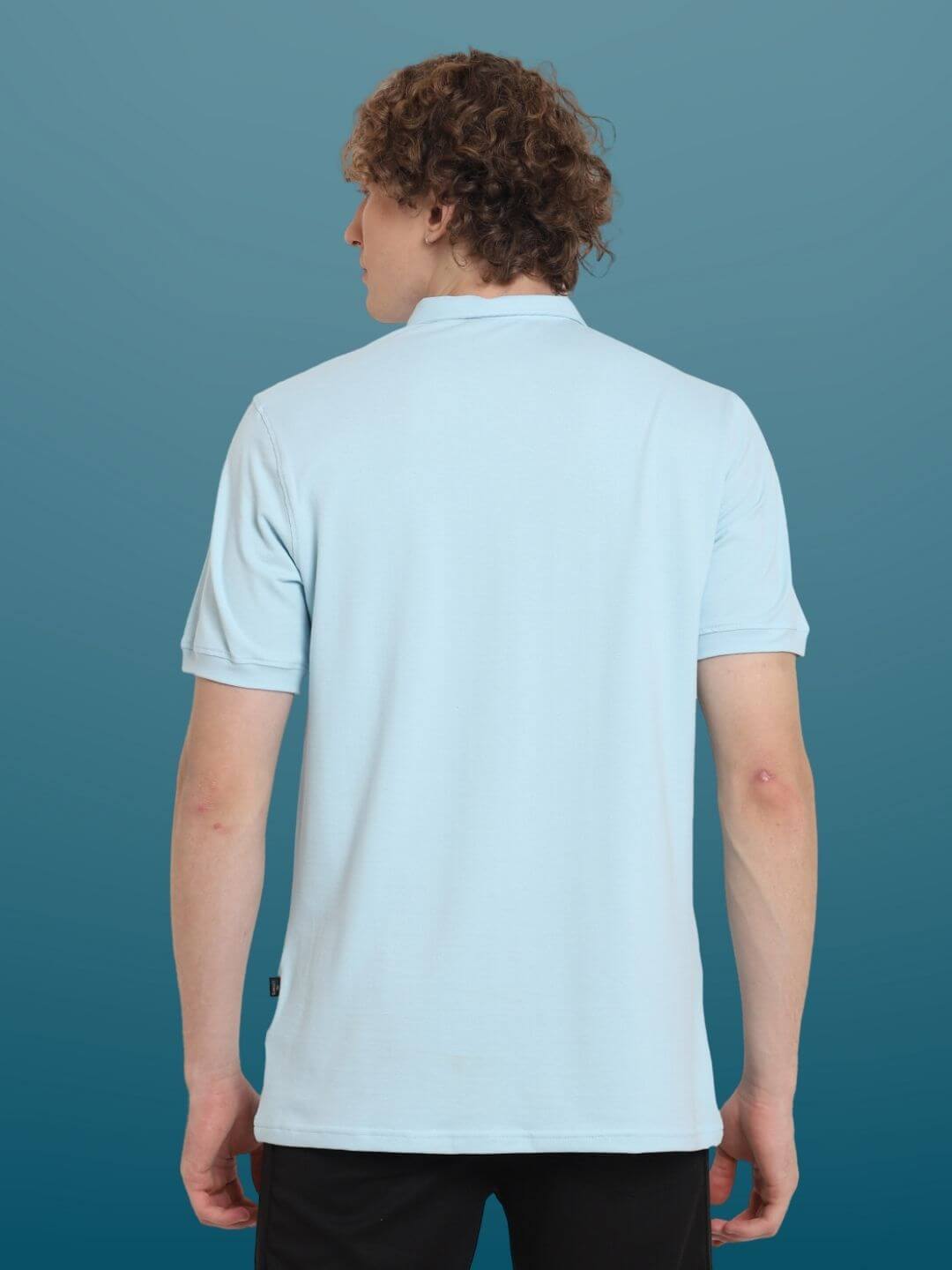 Back view of a man wearing a powder blue zipper polo neck t-shirt made from stretchy, wrinkle-free cotton lycra.