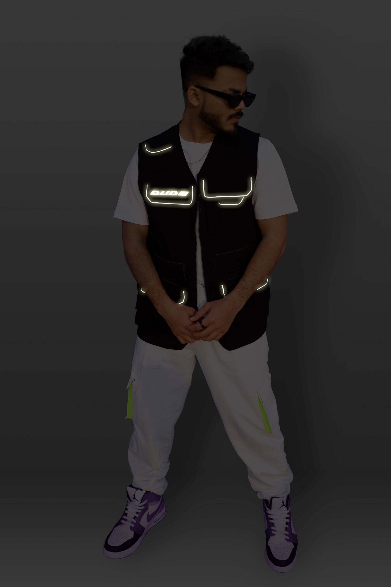 Man wearing MULTI POCKETS REFLECTOR CARGO VEST with reflective detailing, streetwear style